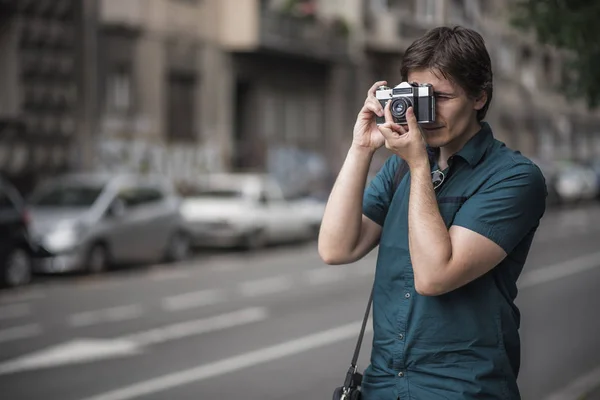 Joven fotógrafo tomando fotos callejeras — Foto de Stock