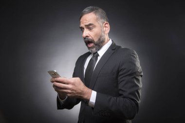 Cep telefonundan aldığı mesajla büyük bir şok içinde olan kıdemli iş adamı