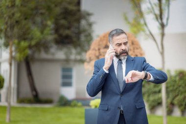 Kıdemli olgun iş adamı zaman ile şok, onun telefonda konuşurken, korkusunu ifade