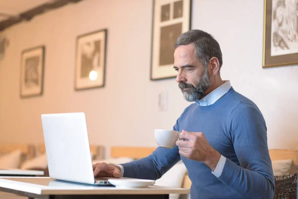 Hombre Mayor Casual Sentado Una Cafetería Tomando Café Mientras Navega —  Fotos de Stock