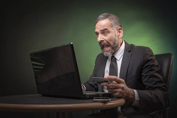 Üst düzey iş adamı tamamen onun laptop kontrol ediyor onun kredi kartı dengesi ile şok