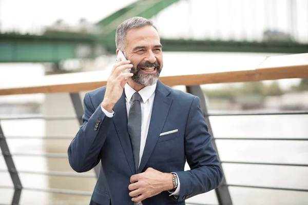 Street yürüyüş ve cep telefonundan, kentsel açık alan konuşurken rahat üst düzey iş adamı