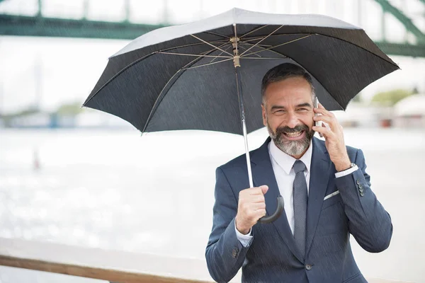Telefon biznesowy, odkryty deszczowy dzień rozmawiać — Zdjęcie stockowe