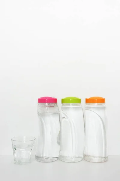 Plastikflaschen Mit Trinkwasser Und Glas Auf Weißem Hintergrund Kopierraum — Stockfoto