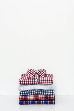 Beyaz arkaplanda izole edilmiş renkli tişört yığını, kopyalama alanı 