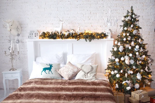 Рождественская елка с белой кроватью в белой комнате — стоковое фото