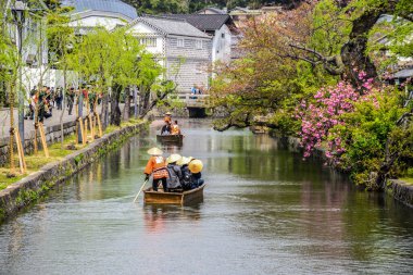 Japonya 'da Kurashiki nehrindeki küçük teknedeki Japonlar.