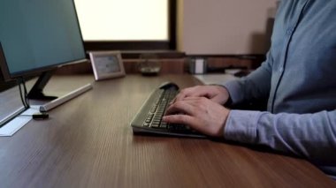 Mavi tişörtlü, daktilo yazan önemli bir adam. 