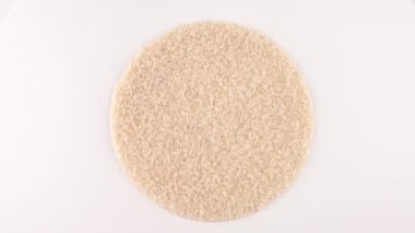 Daire şeklinde saf beyaz pirinç yığını dönüyor.