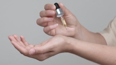 Bir kadının eli lavanta yağı döker. 