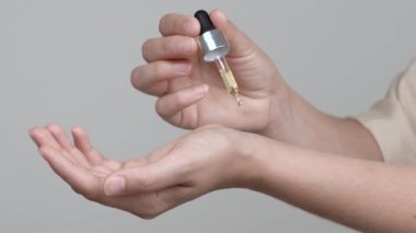 Bir kadının eli lavanta yağı döker. 