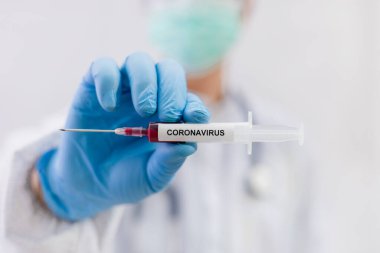 Coronavirus (COVID-19) için hastaların kan örneklerini test eden doktor, içinde koronavirüs pozitif veya negatif bir kan örneği bulunmayan bir test tüpü tutar..