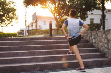 Spor salonundaki kadınlar ısınmadan önce köy parkında koşuyorlar.