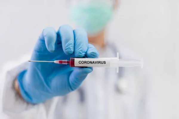 Laboratory testing patients blood samples for presence of coronavirus (COVID-19) The doctor holds a test tube containing a blood sample that has no the result positive or negative for coronavirus.