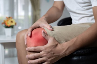 Koltukta oturan adam diz ağrısından muzdarip. Acı alanında boya rengi.