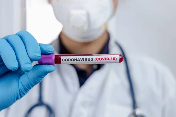 Laboratory testing patients blood samples for presence of coronavirus (COVID-19)The doctor holds a test tube containing a blood sample.,medical concept.