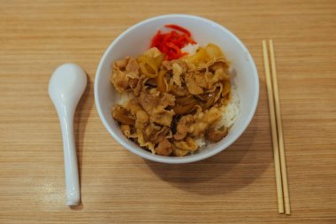 buta donburi (domuz etli pilav) kaşık ve pirzola çubuğu ile