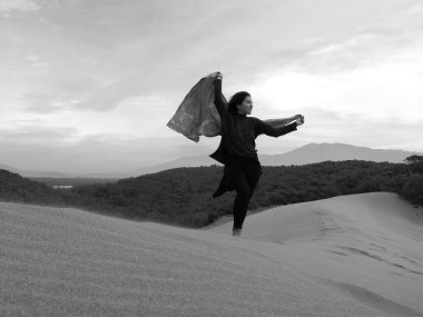 Mutlu kadın gülümsüyor ve sahilde eğleniyor. Siyah ve Beyaz