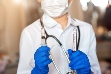 2019 nKoV, Coronavirus kan örneği ve bir doktorun elinde virüsün aşısı olan şırınga. Crown virüs salgını. Salgın Viral Solunum Sendromu