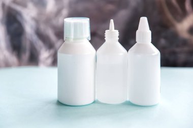 Hafif arka planda uyuşturucu için üç beyaz ilaç şişesi.