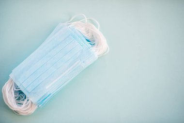 Tıbbi maskeler, tıbbi koruyucu maske, mavi arka planda izole edilmiş. Tek kullanımlık yüz maskesi ağız ve burnu kapatır. Sağlık Hizmetleri Coronavirüs Karantinası, Hijyen Konsepti