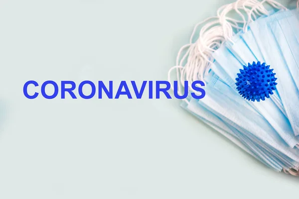 Niebieski Model Wirusowy Medyczne Maski Ochronne Napis Koronawirusa Jasnym Tle — Zdjęcie stockowe