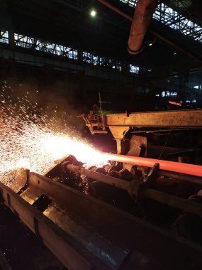 Fabrika atölyesindeki endüstriyel bir fırında yüksek sıcaklıkta çelik sertleşmesi. Metalurji endüstrisi, çelik üretimi, sıcak rulo fabrikası