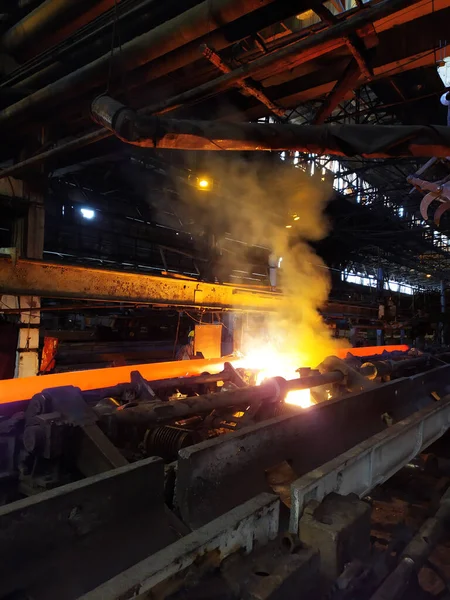 Fabrika atölyesindeki endüstriyel bir fırında yüksek sıcaklıkta çelik sertleşmesi. Metalurji endüstrisi, çelik üretimi, sıcak rulo fabrikası