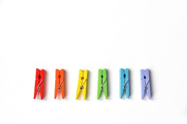 LGBT topluluğu için kartpostal. Beyaz desenli arka planda LGBT renklerinde renkli lothespinler. Fotokopi alanı olan düz konum