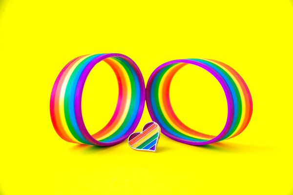 радужные браслеты на желтом фоне. празднование Дня Святого Валентина. Концепция фестиваля ЛГБТ
