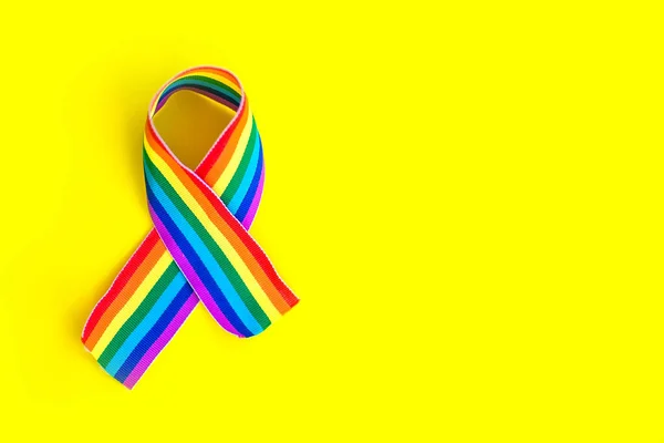 Sarı arka planda LGBT gökkuşağı kurdelesi. Gurur kurdelesi sembolü. Metin için alanı kopyala.