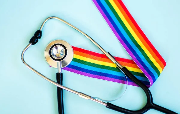 Stetoskop ve LGBT gökkuşağı kurdele gurur sembolü. Mavi arkaplan