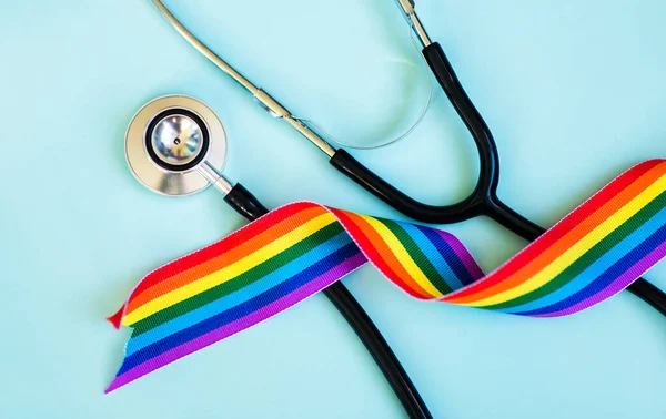 Stetoskop ve LGBT gökkuşağı kurdele gurur sembolü. Mavi arkaplan