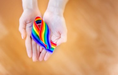 LGBT bantlarından oluşan bir gökkuşağı ile el ele tutuşun. Uzayı metin için kopyala. Homoseksüeller ve LGBT insanları kavramı.