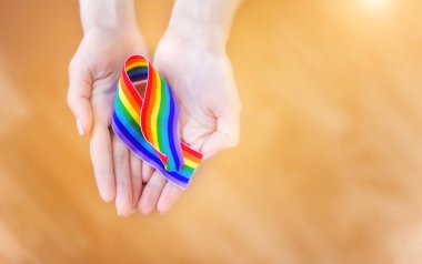 LGBT bantlarından oluşan bir gökkuşağı ile el ele tutuşun. Uzayı metin için kopyala. Homoseksüeller ve LGBT insanları kavramı.