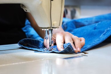 Bir terzinin elleri. Dikiş makinesiyle elbise dikiyor.