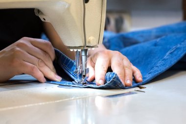 Bir terzinin elleri. Dikiş makinesiyle elbise dikiyor.