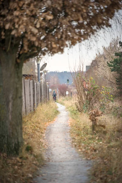 Einsamer Lebensmittelweg mit Radler und Zaun im Hintergrund — Stockfoto