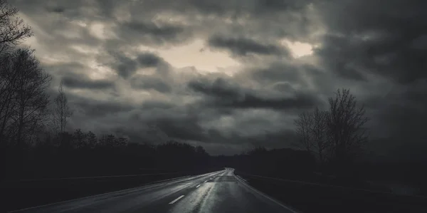 Тёмная дорога на Рождество с облачным небом — стоковое фото