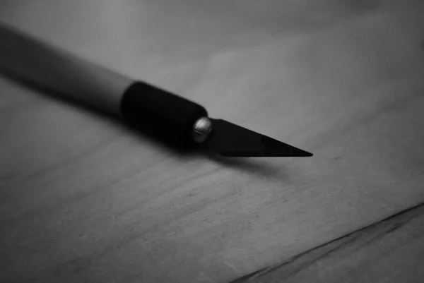 Blurry scalpel on the wooden table in black and white — Stock Photo, Image