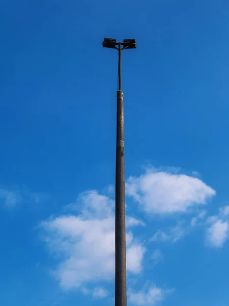Eiserner Laternenpfahl vor blauem bewölkten Himmel — Stockfoto