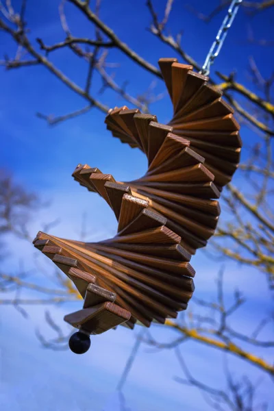 Деревянный колокольчик перед голубым небом, висящим в саду — стоковое фото