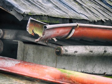 Red old damaged roof gutter