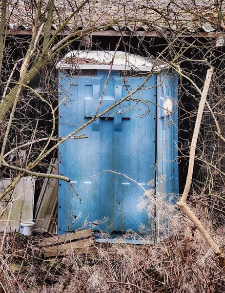 Old blue outhouse in the backyard of a garden — Stok fotoğraf