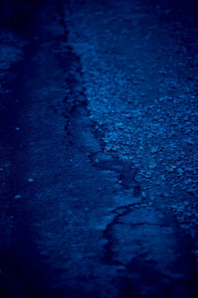 Podrobnosti o poškozené asfaltové cestě tónované modře — Stock fotografie