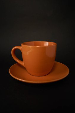 Turuncu kahve fincanı ve çay tabağı.