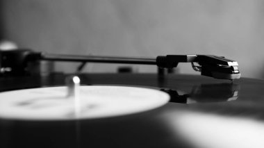 Siyah ve beyaz vinil iğne stili kopyalama alanı ile dönen siyah vinil disk üzerinde. Turntable vinil kaydedici.
