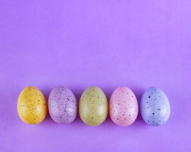 Eflatun arkaplanda çok renkli Paskalya yumurtaları