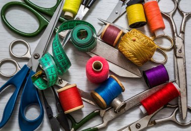 ewing araçları ve aksesuarları dikmek için renkli iplikler, bobinler, makas, düğmeler, iğneler, iğne ve terziler beyaz bir arkaplan üzerinde dikiş aksesuarları konsepti, yukarıdan görünüm