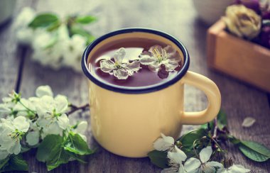  Metal bardakta elma ağacı çiçeklerinden yapılmış sağlıklı bir çiçek çayı. Terapi içeceği. Çok güzel kokuyor. - Uyuşturucu. Retro renkli.